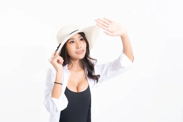 在摄影棚拍摄的一个戴着海滩帽 泳衣和白衬衫的快乐的年轻女子的画像 背景是白色的 与阳光隔离 暑期旅行概念 — 图库照片