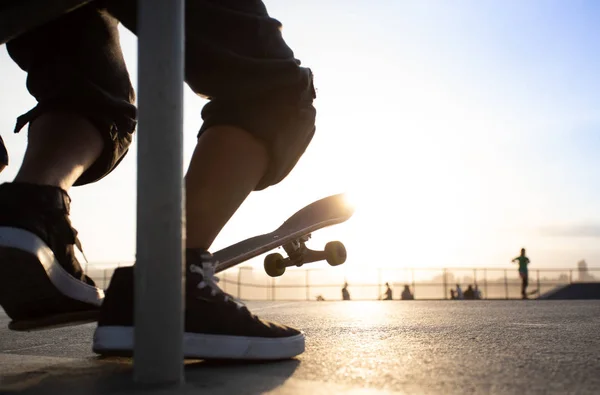 Meninos praticando skate durante o pôr do sol — Fotografia de Stock