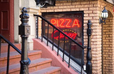 Kırmızı ışıklı pizza satan bir lokantanın ayrıntıları.