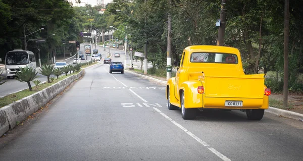 A yellow 1960 Ford Pick-up, fully restored, running through the — 图库照片