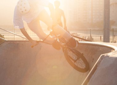 BMX bisikletçisi kasede numaralar yapıyor.