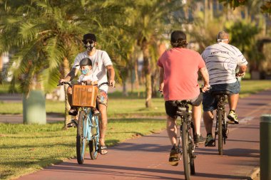 Santos, Brezilya. 09 Mayıs 2020. Babası bisikletle Santos, Brezilya 'da karantina sırasında oğlunu gezdiriyor..