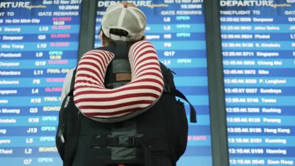 Backpacker überprüft Fluginformationen auf digitaler Flugplananzeige im iairport — Stockvideo