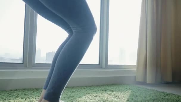Junge Frau praktiziert Yoga zu Hause mit Stadtbild Hintergrund — Stockvideo