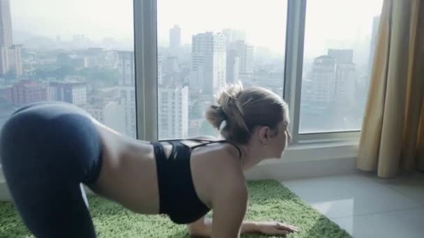 Giovane donna che pratica yoga a casa con sfondo paesaggio urbano — Video Stock