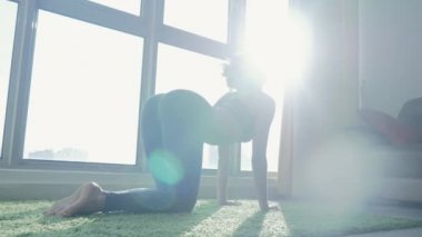 Genç kadın cityscape arka plan ile evde Yoga pratik