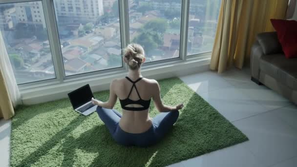 Chica joven practicando meditación en casa con fondo de paisaje urbano — Vídeo de stock