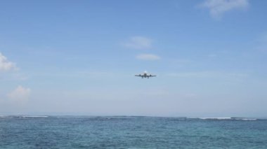 Açılış Adası Bali Havaalanı altında mavi deniz dalgaları ufukta uçak
