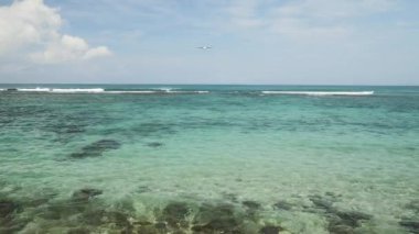 Açılış Adası Bali Havaalanı altında mavi deniz dalgaları ufukta uçak