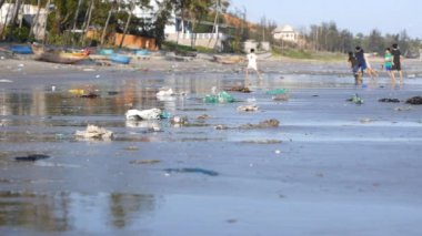 Odak içinde çöp, çöp kirli plajda oynayan çocuklar atış statik