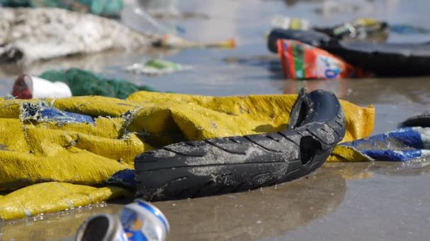 Handheld close up shot of trash and rubbish on the shore of a tropical sea — Stock Video