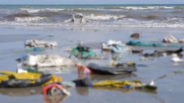 바다의 정적 샷입니다. 플라스틱 쓰레기와 defocus 해변에 쓰레기의 클로즈업. — 비디오