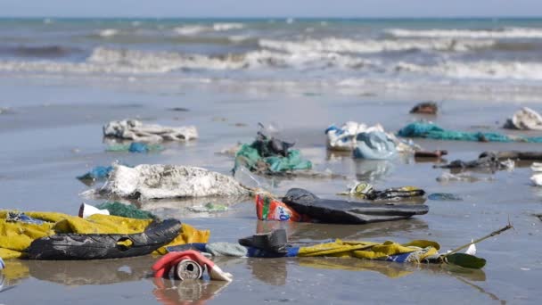 Panoramique gros plan des déchets en plastique et des déchets sur la plage sur fond de mer — Video