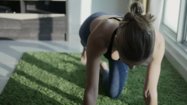 Genç kadın cityscape arka plan ile evde Yoga pratik