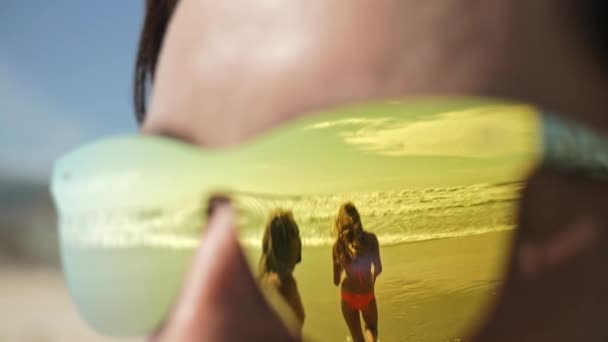 反射在朋友的太阳镜中奔跑到海. — 图库视频影像