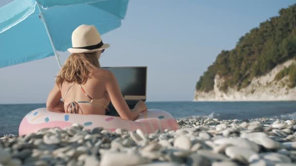 Young girl working on laptop outdoors in summer vacation — Stock Video