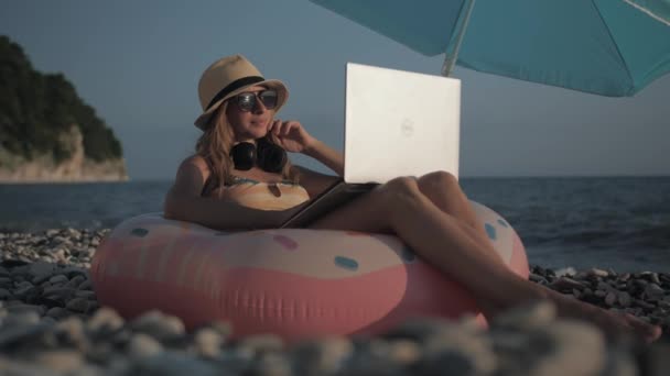 Jong meisje werken op laptop buiten in de zomer vakantie — Stockvideo