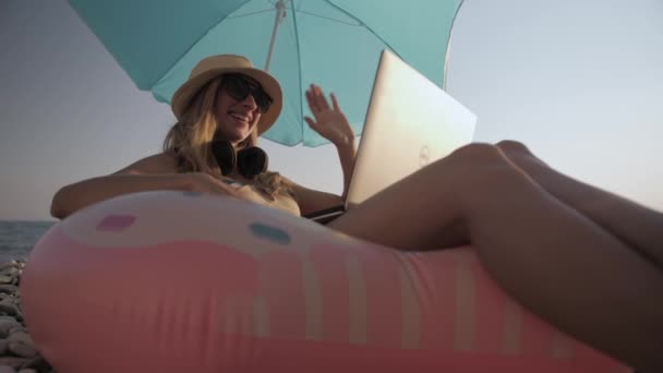 Mladá dívka pracující na notebooku venku v letní dovolené — Stock video