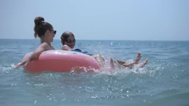 Familia relajándose en la rosquilla inflable del juguete, nadando en mar azul — Vídeo de stock