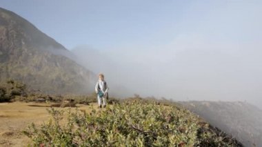 Çocuk dağda tek başına yürüyüş yapıyor.