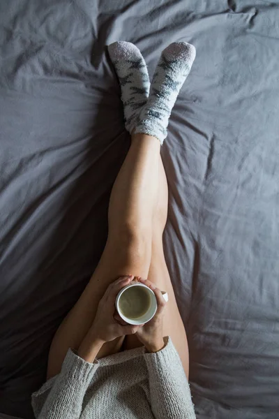 Jeune femme prenant un café sur le lit — Photo