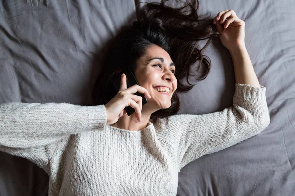 Wanita muda berbicara di telepon dan tersenyum — Stok Foto