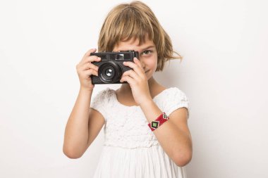 vintage bir kamera ile oynamaya ve having fun küçük kız. Beyaz 
