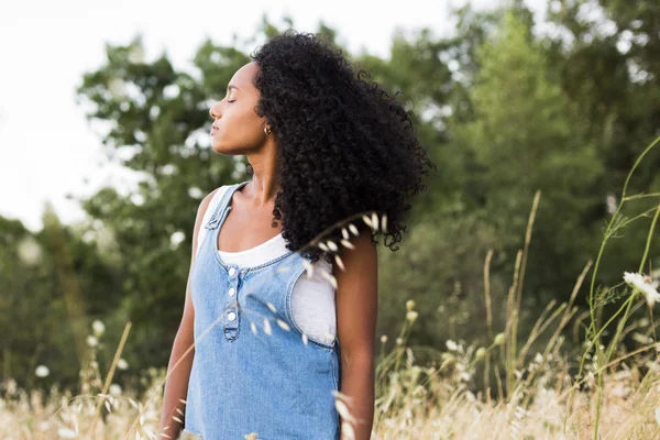 Potret di luar ruangan seorang wanita afro amerika muda. Backgro kuning — Stok Foto