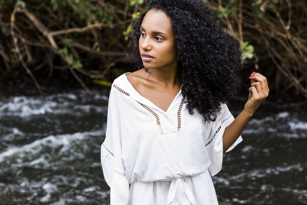 portrait outdoors of a beautiful young afro american woman at su