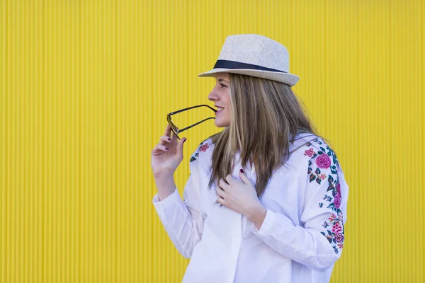 Beautiful young woman with hat and sunglasses having fun. Yellow — Stock Photo, Image