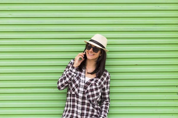 Happy beautiful woman talking on the phone over green background — Stok Foto