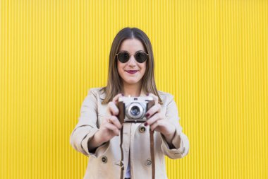 portre bir vintage fotoğraf makinesi y üzerinde tutan bir genç güzel kadın