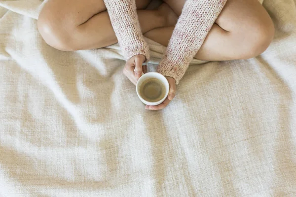 Jeune femme dégustant son café assis au lit. Vue du dessus . — Photo