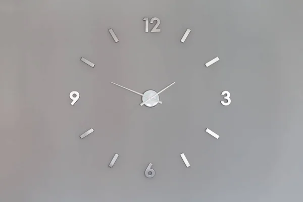 Silver shiny clock numbers at the wall with copy space