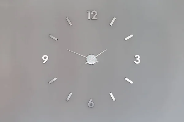 Números de relógio brilhantes prateados na parede com espaço de cópia Fotografia De Stock