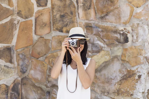 Retrato de una joven hermosa mujer sosteniendo una cámara vintage sobre s — Foto de Stock