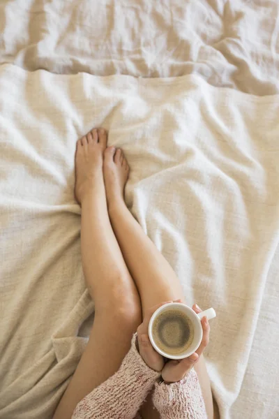 Vacker ung kvinna njuter av kaffe på säng i hennes sovrum — Stockfoto