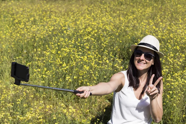 Heureux belle jeune femme prendre un selfie sur vert et jaune — Photo