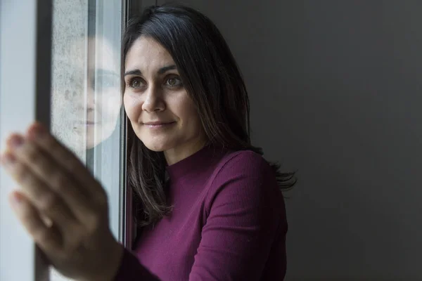 Belle femme regardant par la fenêtre, de jour — Photo