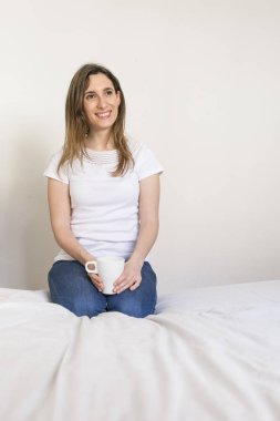 bir fincan kahve yatak odasında tutan güzel genç kadın. si