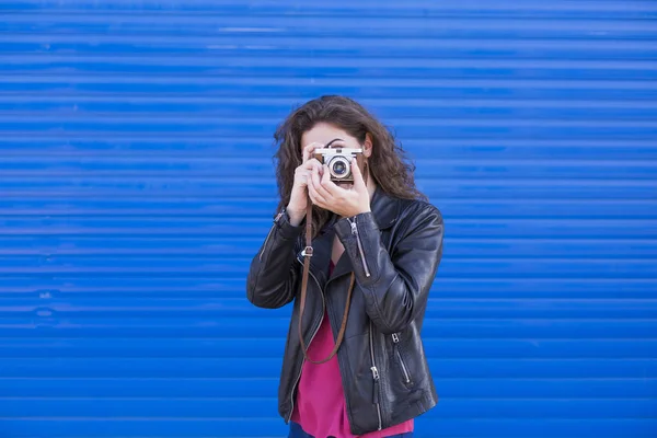 Retrato de una joven hermosa mujer sosteniendo una cámara vintage sobre b —  Fotos de Stock