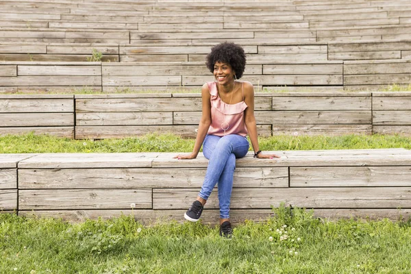 행복 한 젊은 아름 다운 아프리카 미국의 앉아있는 여자의 초상화 스톡 사진