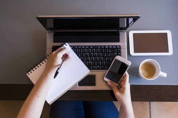 Kahve, smartpho ile dizüstü bilgisayar üzerinde çalışan kadın Üstten Görünüm