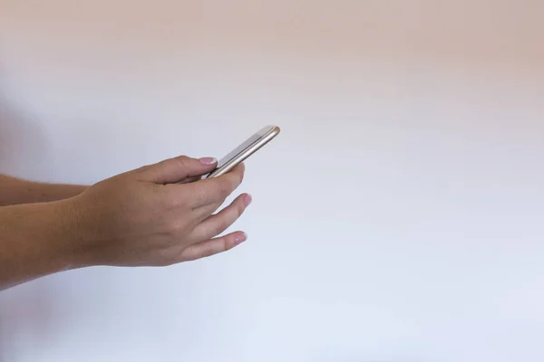 Close up view of a woman holding a smart phone over white backgr — Stok Foto