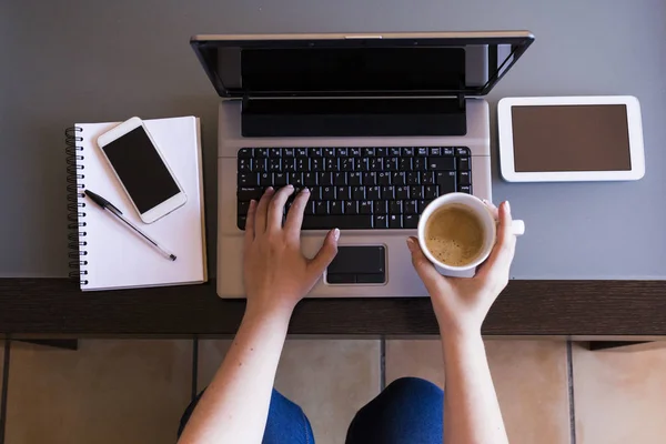 Vue du dessus de la femme travaillant sur un ordinateur portable avec une tasse de café, smartpho Photos De Stock Libres De Droits
