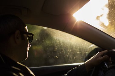 Gökyüzü günbatımı akşam hafif bir araba adam. Sunglasse giyiyor