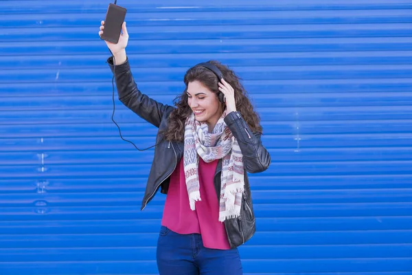 Portrait of a beautiful young woman listening to music on her mo — Stock Photo, Image