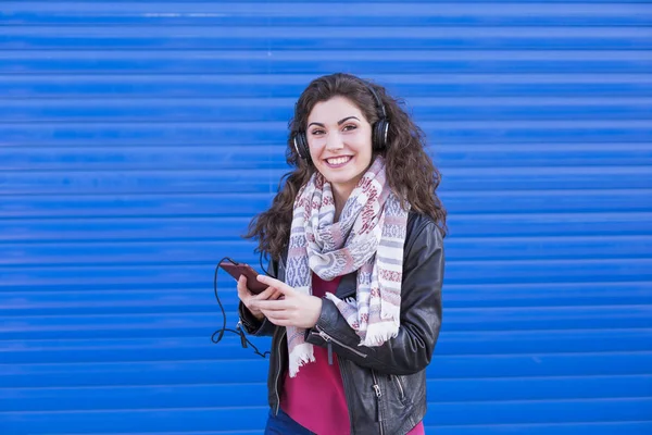 Portrait of a beautiful young woman listening to music on her mo — Stock Photo, Image