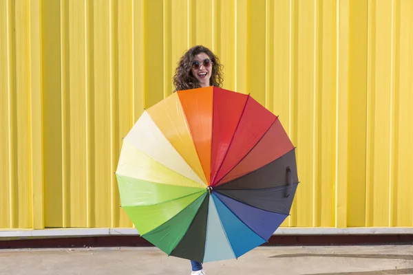 Jovem mulher bonita se divertindo com um guarda-chuva colorido sobre y Imagens De Bancos De Imagens