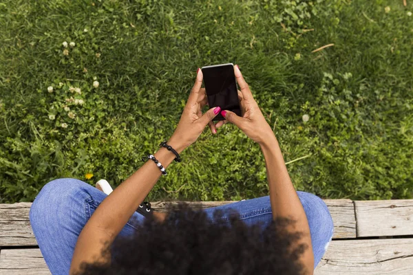 Top pandangan seorang wanita muda afro Amerika menggunakan ponsel. Gree — Stok Foto